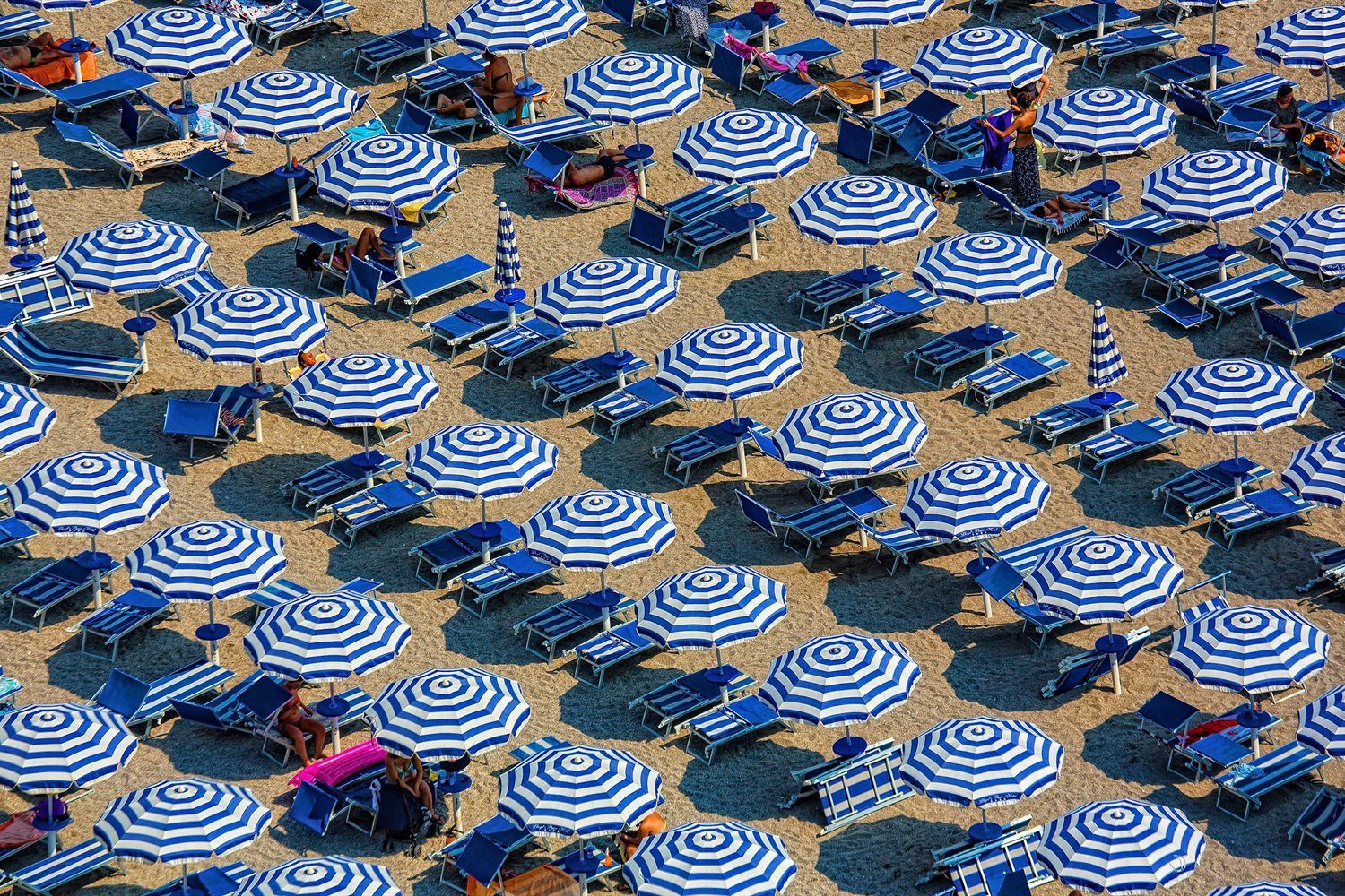 Vista aérea de guarda-sóis numa praia italiana lotada